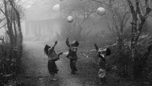 Trẻ em dân tộc H'mông đang chơi đùa với những quả bóng bay trong sương mù ở Mộc Châu, Sơn La
